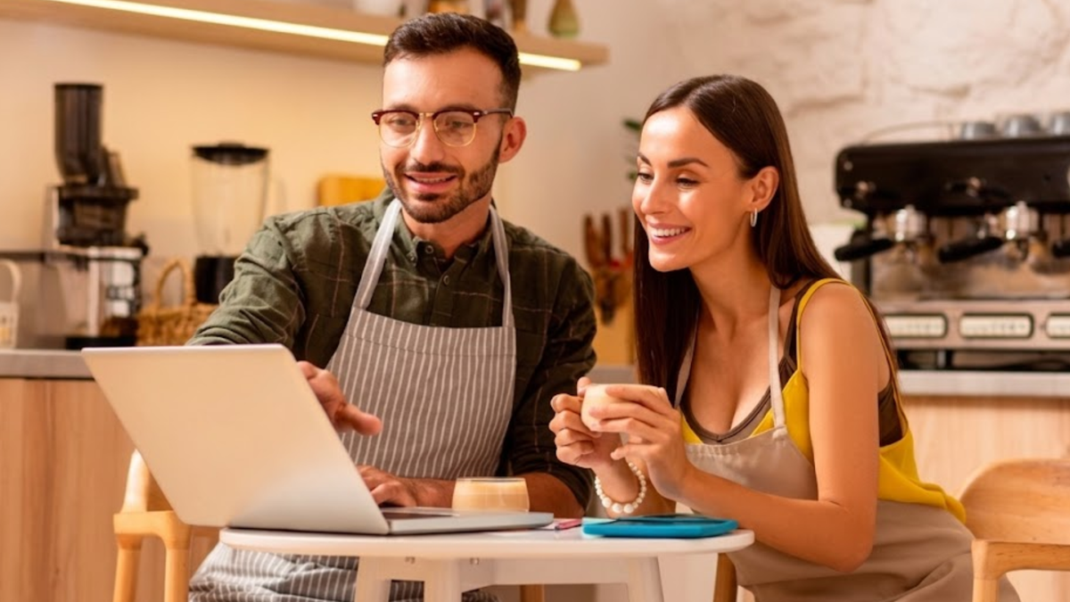 Ondernemers bekijken verkoopcijfers en boekhouding op een laptop